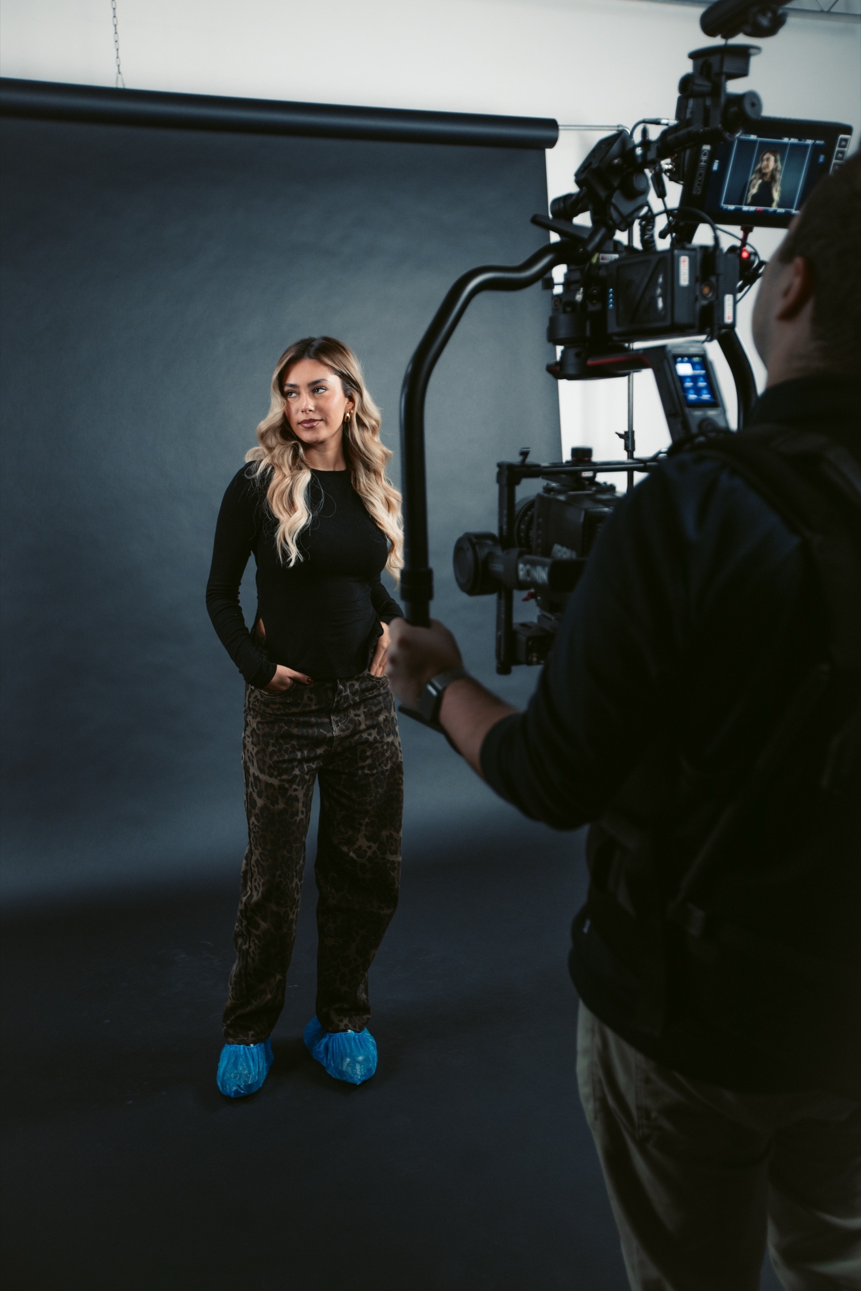 Studiodreh bei Florian Media: Kameramann mit Gimbal filmt eine Protagonistin vor dunklem Hintergrund