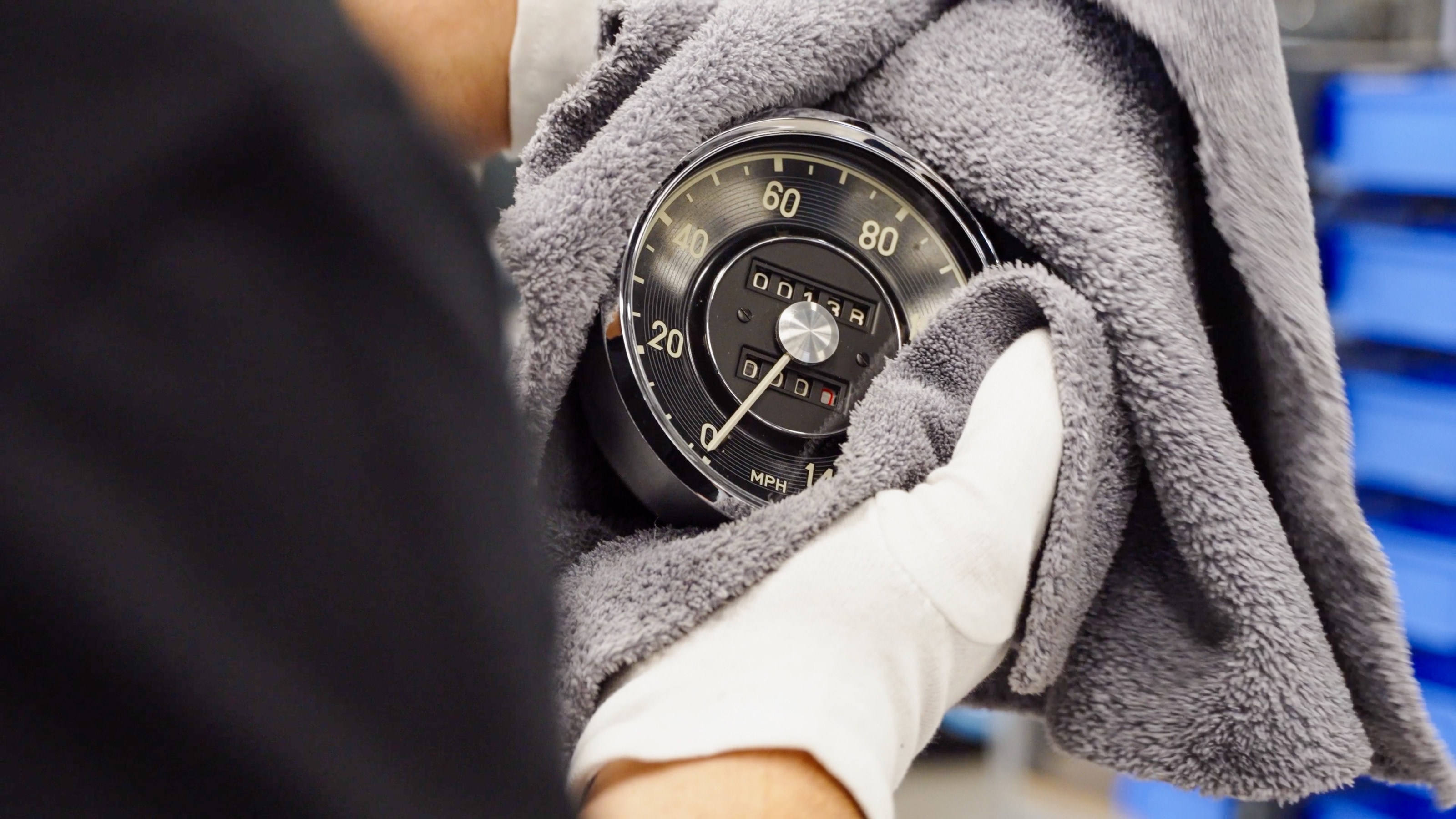 Behandschuhte Hand poliert den Tachometer des 190 SL mit einem Tuch