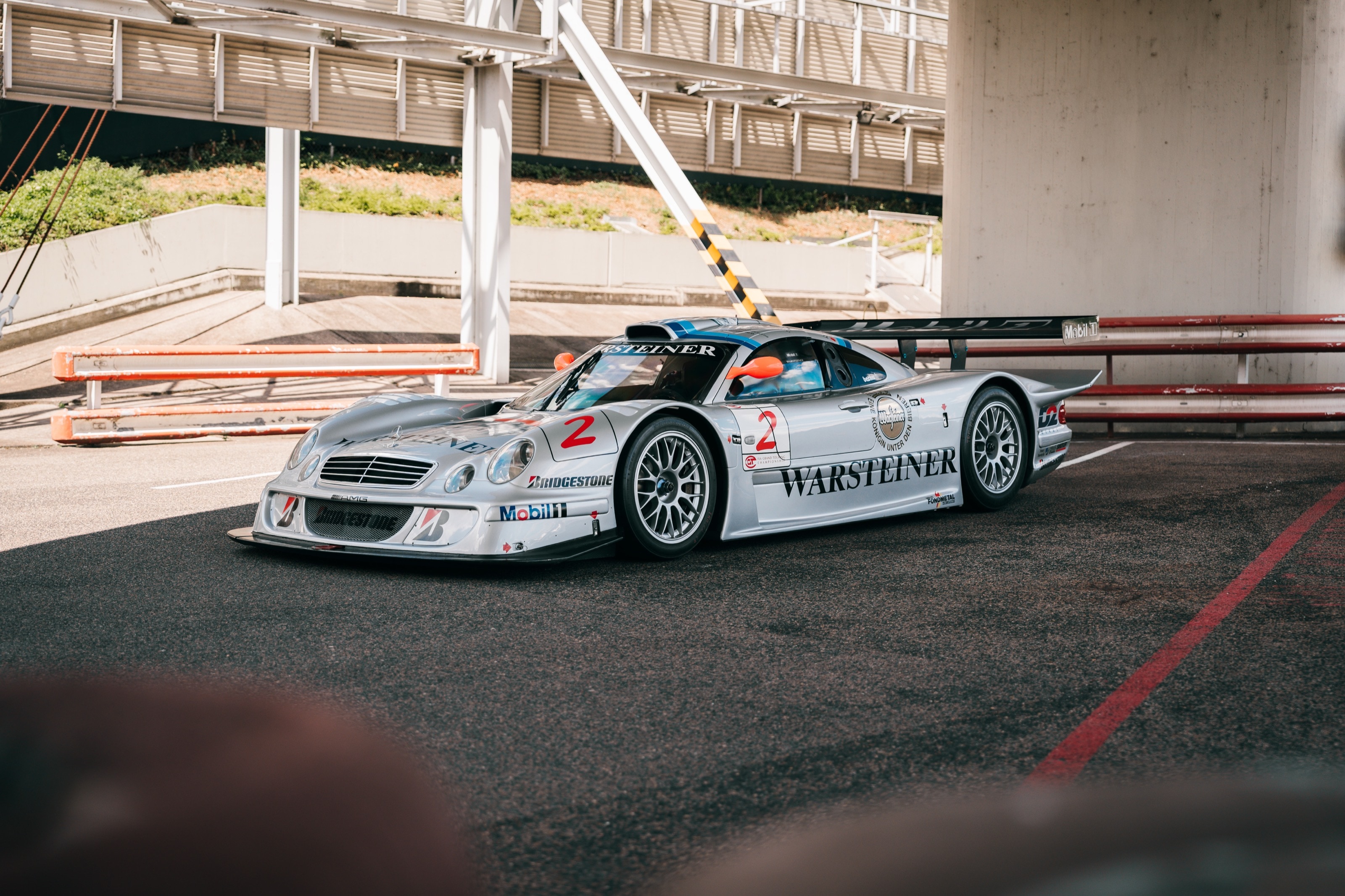 Die Rennversion des CLK GTR mit Startnummer 2 und Warsteiner-Lackierung unter der Brücke der Einfahrbahn