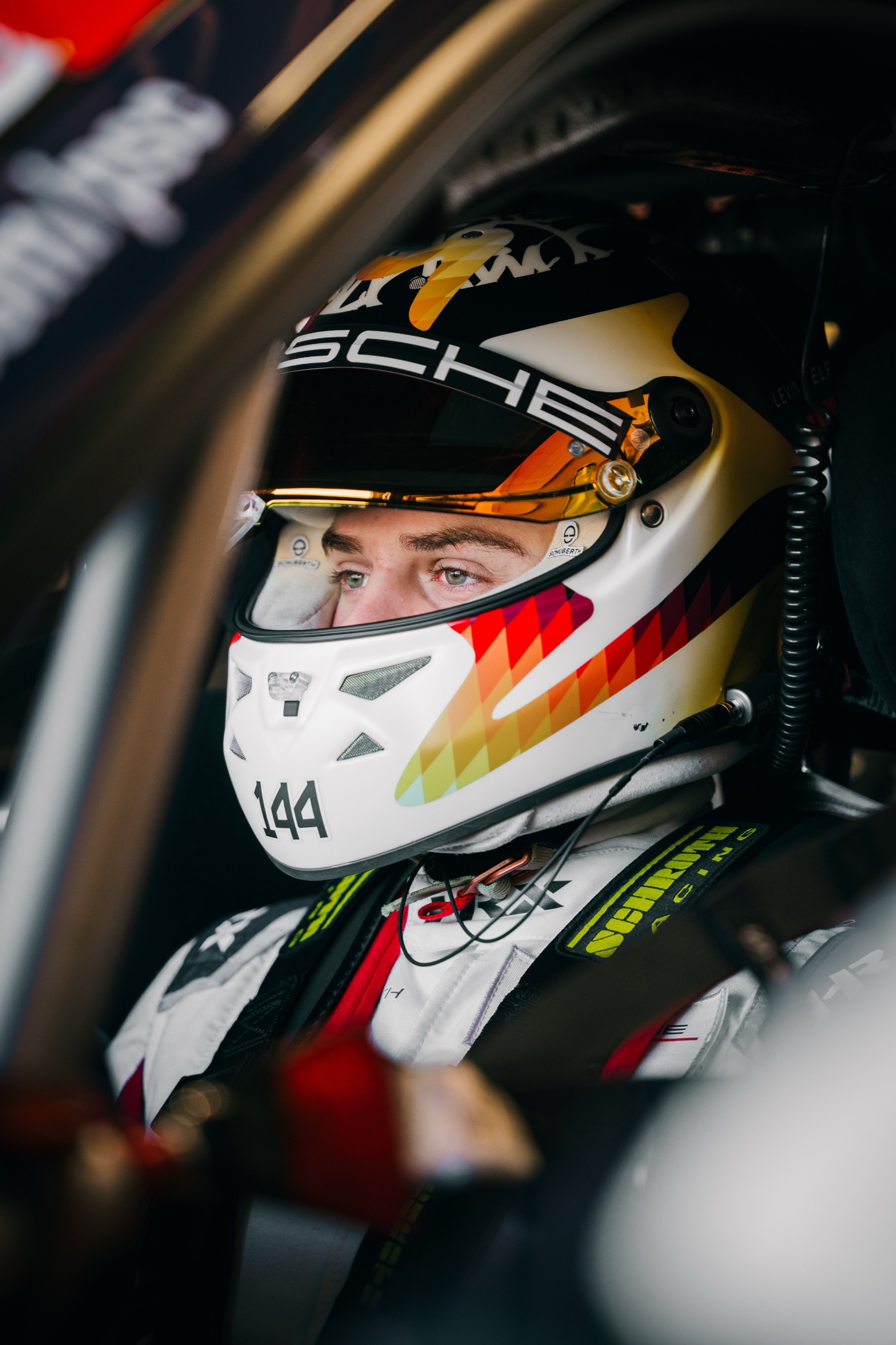 Nahaufnahme des Fahrers mit Helm und Startnummer 144 im Cockpit