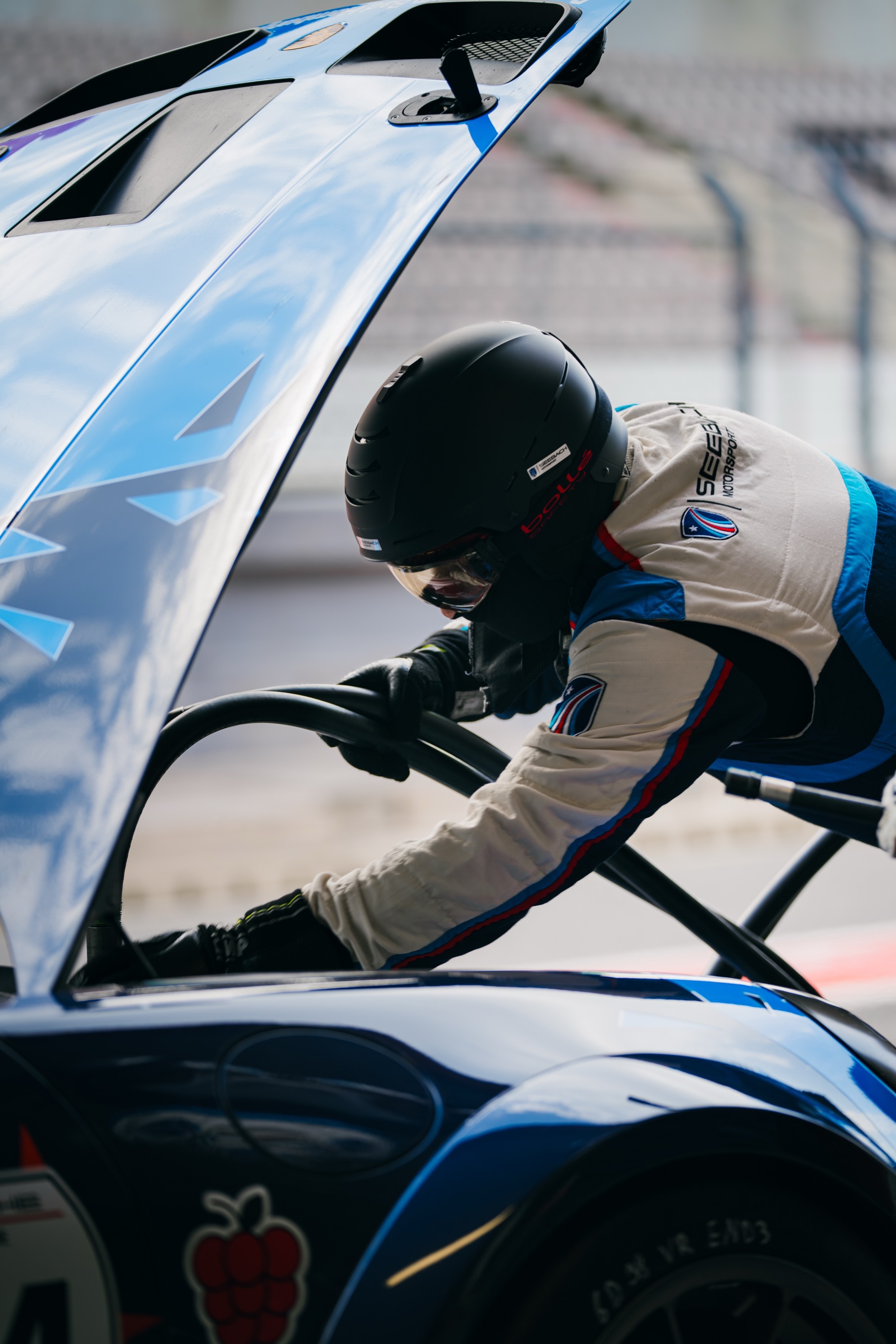 Mechaniker beugt sich unter die geöffnete Haube des 911 GT3 Cup