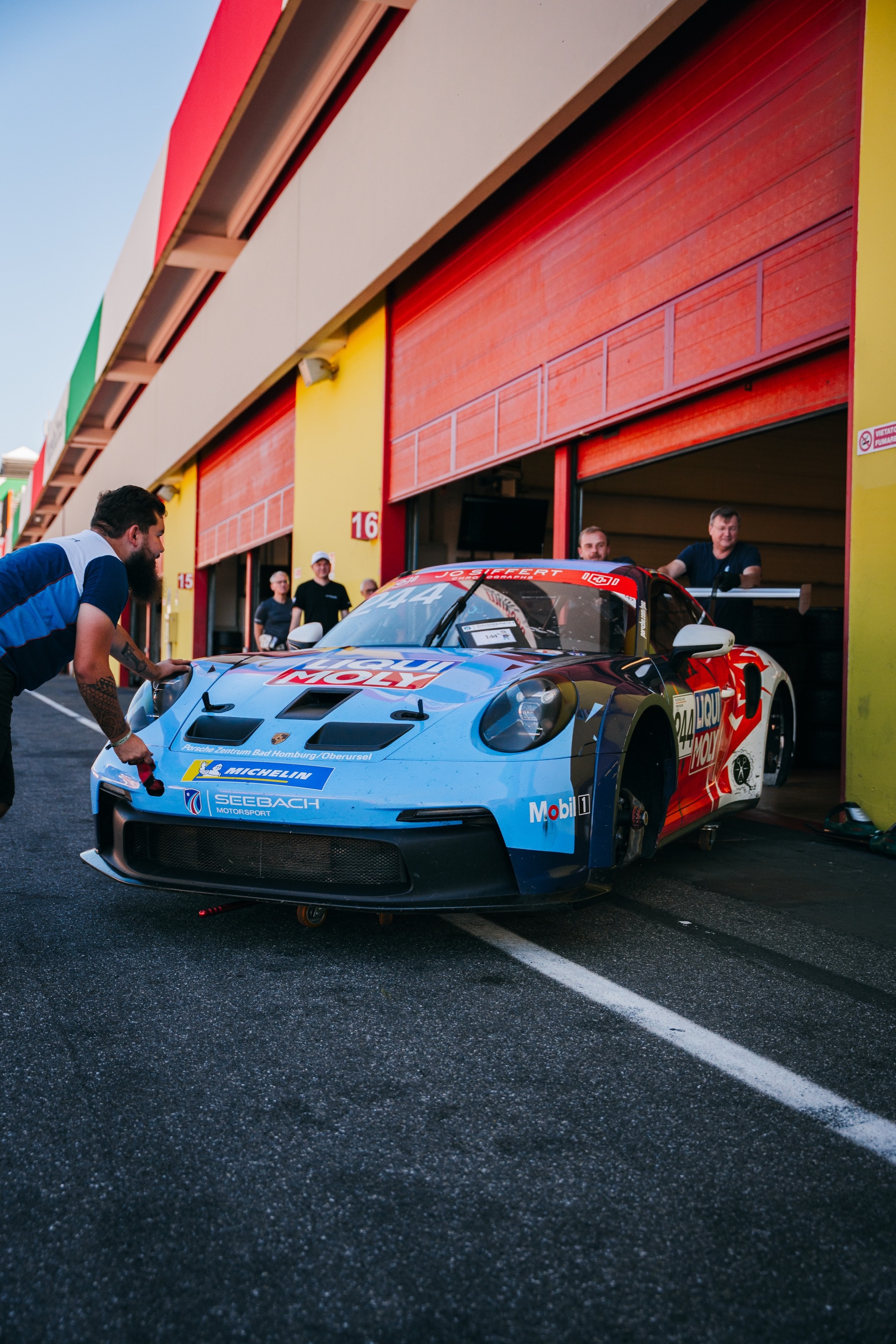 Mechaniker schieben den blauen 911 GT3 Cup aus der roten Box in Mugello
