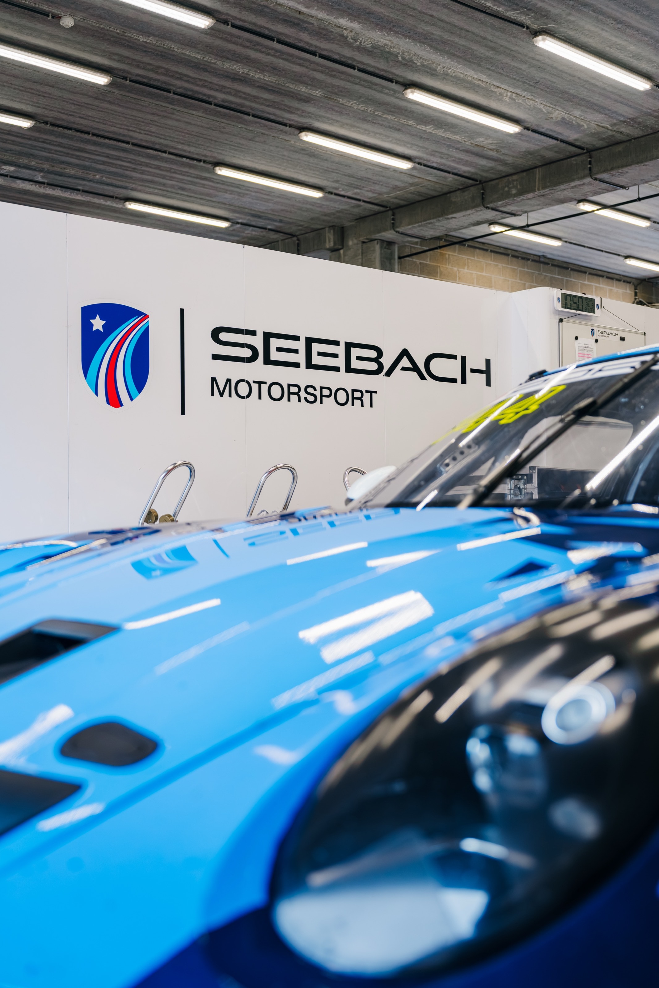 Der blaue 911 GT3 Cup in der Box vor dem Logo von Seebach Motorsport